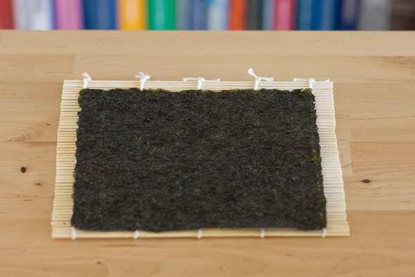 Lay the sheet of seaweed with its prettier side facing down.